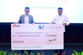 MES Group founder and chief executive Mohamed Abdul Jaleel Muthumaricar S M (right) presents a cheque to ST editor Jaime Ho at the appreciation lunch on Oct 4.