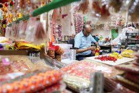 Mr R. Jayaselvam, owner of Anushia Flower Shop, making flower garlands using Button Roses at his shop in Little India.