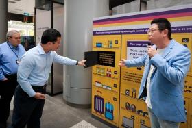 National Development Minister Desmond Lee (left) at a presentation by Pick Network CEO New Soon Tee during an exhibition launch at the URA Centre on Nov 15.