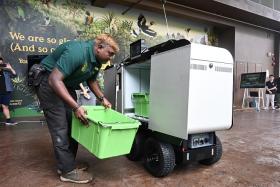 Mr Prakash Sudandiran, assistant manager, animal care, Mandai Wildlife Group, loading containers of animal feed into the Delivery Autonomous Mobile Robot.