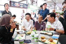 Prime Minister Lawrence Wong (centre) and Deputy Prime Minister Heng Swee Keat (right) having breakfast with stall owners of Azman Seafood Restaurant in New Upper Changi Road on Dec 14.