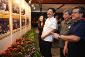 Prime Minister Lawrence Wong and Minister for Culture, Community and Youth Edwin Tong (extreme right) viewing a photo exhibition on community clubs over the years on Nov 4.